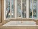 Soaking tub in bathroom area featuring custom shutters and marble surround at 174 Buena Ct, Henderson, NV 89074