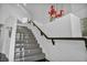 Elegant staircase with marble steps, a sleek black handrail, and white walls at 174 Buena Ct, Henderson, NV 89074