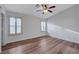 A bright bedroom featuring hardwood floors, ceiling fan, and shuttered windows at 2517 New Salem Ave, Henderson, NV 89052