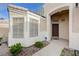 Close-up of the front entry featuring a wood door, security system, and meticulously maintained landscaping at 2517 New Salem Ave, Henderson, NV 89052