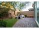 Serene backyard with brick-paved patio, outdoor seating, vibrant landscaping, and mature trees at 343 Cadence Vista Dr, Henderson, NV 89011
