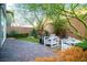 Private backyard features brick-paved patio, cozy seating, lush greenery, and mature desert landscaping at 343 Cadence Vista Dr, Henderson, NV 89011