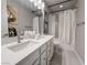 Modern bathroom features double sink vanity, tiled shower-tub combo, decorative art, and contemporary fixtures at 343 Cadence Vista Dr, Henderson, NV 89011