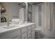 Modern bathroom features double sink vanity, tiled shower-tub combo, decorative art, and contemporary fixtures at 343 Cadence Vista Dr, Henderson, NV 89011