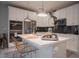 Modern kitchen boasts white cabinets, stainless steel appliances, and a stylish island with seating at 343 Cadence Vista Dr, Henderson, NV 89011