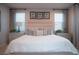 Cozy main bedroom featuring a upholstered bed and three windows at 343 Cadence Vista Dr, Henderson, NV 89011