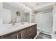 Bathroom with dual vanity, dark wood cabinets, and sleek glass shower offers comfort at 4650 Wonderful St, Las Vegas, NV 89147