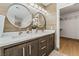 Modern bathroom features a double sink vanity with round mirrors and wood-look tile walls at 4650 Wonderful St, Las Vegas, NV 89147
