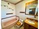 Bathroom featuring a bathtub, toilet, vanity with wood accents and ample lighting at 4964 Dunkirk Ave, Las Vegas, NV 89121