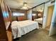 Bedroom with a large mirror closet, neutral carpeting, ceiling fan, and wood paneled wall at 4964 Dunkirk Ave, Las Vegas, NV 89121