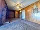 Spacious living room featuring wood paneling, a fireplace, and carpet at 4964 Dunkirk Ave, Las Vegas, NV 89121