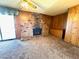 Spacious carpeted living room featuring a brick fireplace and wood paneling at 4964 Dunkirk Ave, Las Vegas, NV 89121