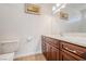 Bathroom with a dark wood vanity, white countertop, sink, toilet, and mirror with decorative lighting at 5090 N David St, Pahrump, NV 89060