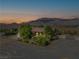 Aerial view of a home surrounded by mature trees and a view of mountains in the distance at 5090 N David St, Pahrump, NV 89060