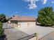 Exterior view of an attached three-car garage with iron gate and a low maintenance yard at 5090 N David St, Pahrump, NV 89060