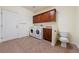 Well-equipped laundry room features modern washer and dryer, tile floors, and wooden cabinets for convenient storage at 5090 N David St, Pahrump, NV 89060