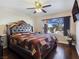 Bedroom with a large window providing natural light, a ceiling fan, and dark hardwood floors at 5092 Mandalay Springs Dr # 201, Las Vegas, NV 89120