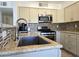 Updated kitchen showcasing granite countertops, stainless steel appliances, and mosaic tile backsplash at 5092 Mandalay Springs Dr # 201, Las Vegas, NV 89120