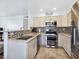 Modern kitchen with granite countertops, mosaic backsplash, stainless appliances, and convenient breakfast bar at 5092 Mandalay Springs Dr # 201, Las Vegas, NV 89120