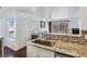 Modern kitchen with stainless steel sink, granite countertops, and mosaic backsplash at 5092 Mandalay Springs Dr # 201, Las Vegas, NV 89120