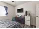 Well-lit bedroom with gray bed, mounted television, and convenient door access to other spaces at 5508 Pride Mountain St, North Las Vegas, NV 89031