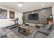 Well-lit living room with a wood accent wall, a comfortable sofa, and a treadmill at 5508 Pride Mountain St, North Las Vegas, NV 89031