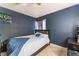 Bedroom with navy blue accent wall, ceiling fan, and window with sheer curtains at 6224 Mandarin Dr, Las Vegas, NV 89108