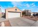 A tan home has a garage and easy-care desert landscaping under a blue sky with scattered clouds at 6224 Mandarin Dr, Las Vegas, NV 89108