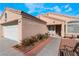 Quaint tan home with a tiled roof, desert landscaping, and a bench out front at 6224 Mandarin Dr, Las Vegas, NV 89108