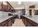 A kitchen featuring granite countertops, stainless appliances, dark wood cabinetry, and tiled floors at 6224 Mandarin Dr, Las Vegas, NV 89108