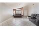 Bright living room with tile floors, neutral paint, and a cozy couch beneath the window at 6224 Mandarin Dr, Las Vegas, NV 89108
