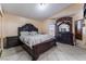 A main bedroom with a dark wood bed set, dresser, and a large mirror at 6224 Mandarin Dr, Las Vegas, NV 89108