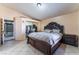 A spacious main bedroom featuring a dark wood bed frame, tile floors, and neutral walls at 6224 Mandarin Dr, Las Vegas, NV 89108