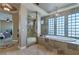 Luxurious bathroom with soaking tub, glass block window, and a separate walk-in shower at 6308 Lauren Ashton Ave, Las Vegas, NV 89131