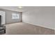 Bright bedroom with neutral carpet and walls, a ceiling light, one window, and a door at 6461 Mount Eden Ave, Las Vegas, NV 89139