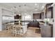 Modern kitchen featuring a large island with seating, stainless steel refrigerator, and dark wood cabinetry at 6461 Mount Eden Ave, Las Vegas, NV 89139