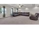 Open-concept living room with neutral carpet, a ceiling fan, recessed lights, and leather sectional seating at 6461 Mount Eden Ave, Las Vegas, NV 89139