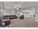 Spacious living room with neutral carpet, recessed lights, coffered ceiling, and leather sectional and chair at 6461 Mount Eden Ave, Las Vegas, NV 89139