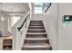 Carpeted staircase with glass railing leads to upper level of home with neutral decor and plenty of natural light at 6461 Mount Eden Ave, Las Vegas, NV 89139
