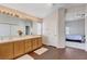 Bright bathroom features double sinks, wood cabinets, large mirror and wood-look flooring at 7624 Nocturne Ct, Las Vegas, NV 89128