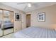 Bedroom with blue bedding reflected in mirrored closet doors and door to hallway at 7624 Nocturne Ct, Las Vegas, NV 89128