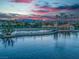 Picturesque community lake surrounded by palm trees, buildings, and distant mountain views at dusk at 7624 Nocturne Ct, Las Vegas, NV 89128