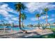 Beautiful community pool with a sandy beach area and swaying palm trees under a bright blue sky at 7624 Nocturne Ct, Las Vegas, NV 89128