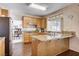 Well-lit kitchen with granite counters, wood cabinets and an open view to the dining room at 7624 Nocturne Ct, Las Vegas, NV 89128