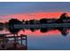 Scenic lake view at dusk, featuring reflections of vibrant sunset colors and surrounding neighborhood at 7624 Nocturne Ct, Las Vegas, NV 89128