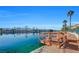 Picturesque lake view featuring blue water, palm trees, a pier, and blue sky at 7624 Nocturne Ct, Las Vegas, NV 89128