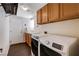 Well-equipped laundry room with modern washer and dryer, cabinetry, and utility sink at 7624 Nocturne Ct, Las Vegas, NV 89128