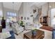 Open-concept living room and dining area with vaulted ceilings, staircase, and large windows at 7624 Nocturne Ct, Las Vegas, NV 89128