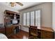 Office with wooden built-in desk, ceiling fan, shutters, and hardwood floors at 7624 Nocturne Ct, Las Vegas, NV 89128