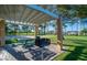 Outdoor picnic area featuring a covered picnic table, barbecue grill, and lush green grass at 7624 Nocturne Ct, Las Vegas, NV 89128
